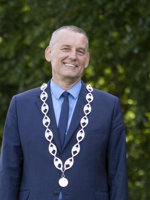 Burgemeester Anton Stapelkamp in blauw kostuum met ketting