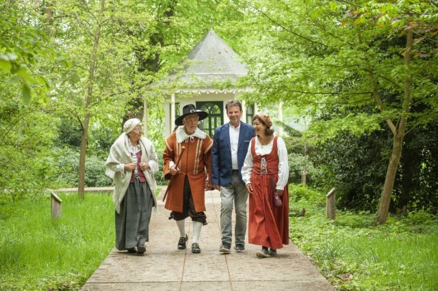 2 mannen en 2 vrouwen in historische kleding op een wandelpad tussen struiken
