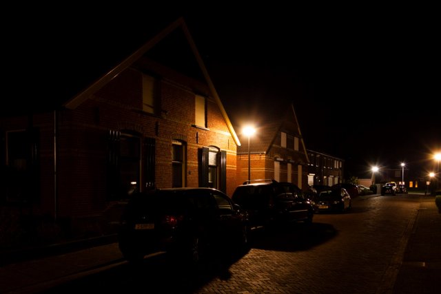 Een lantaarnpaal staat zo dicht op een woning dat de woning ook van binnen wordt verlicht. 