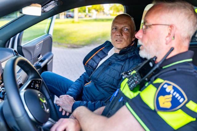 De burgemeester en wijkagent in de auto