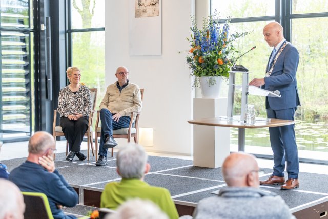 Mevrouw Niesje van de Molen ontvangt de koninklijke speech van burgemeester Jouke Douwe de Vries. Zij is nu lid in de Orde van Oranje Nassau.