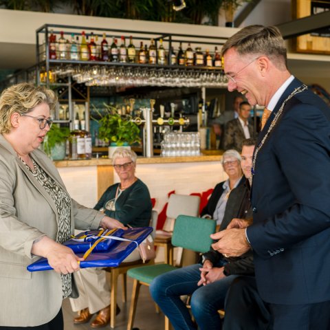 Griffier Jacqueline Metz overhandigt cadeau aan burgemeester Leo Pieter Stoel