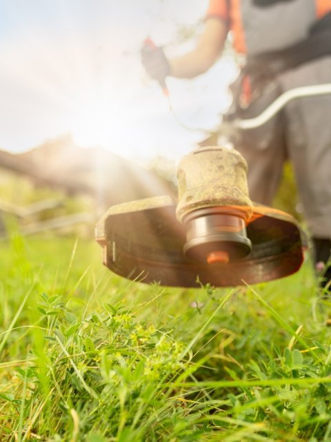 medewerker groenvoorziening die kant maait