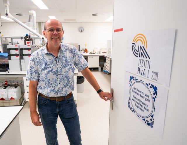 Henk-Jan toont quote op deur laboratorium "Het leveren van kwaliteit kost geld. Het niet leveren van kwaliteit kost kapitalen."