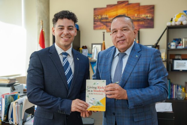 Franklin Seute, autor di “Living Rich as a Student in the Netherlands” a haci entrega di su buki na Minister di Enseñansa y Deporte, Endy Croes.