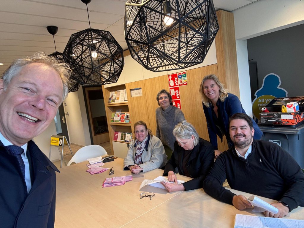 Diverse lachende stembureauleden waaronder Miranda Brey. Op de voorgrond burgemeester Röell