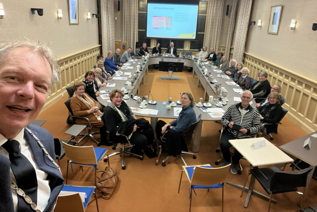 Burgemeester Roëll neemt selfie met de raadsleden en hun gasten in de raadszaal op het gemeentehuis