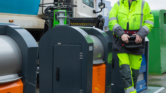 Werknemer loopt langs ondergrondse container