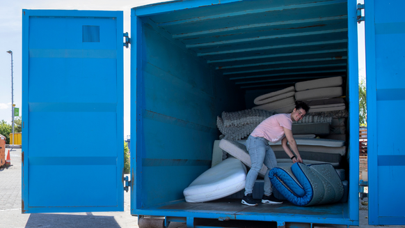 Inwoner legt matras in een container