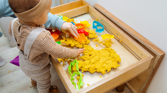 Kind speelt met geel speelzand