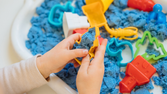 Kind speelt met blauw speelzand