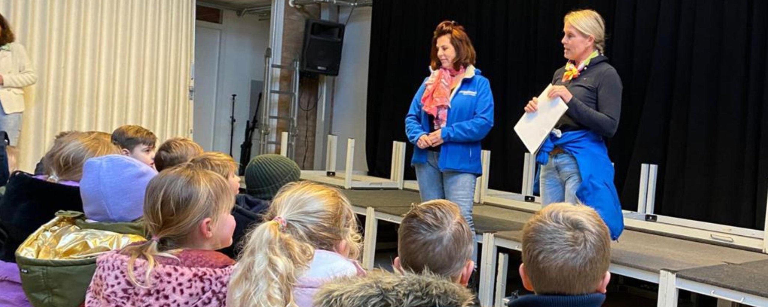 De afvalcoaches van BAR Afvalbeheer geven een presentatie voor een klas met kinderen