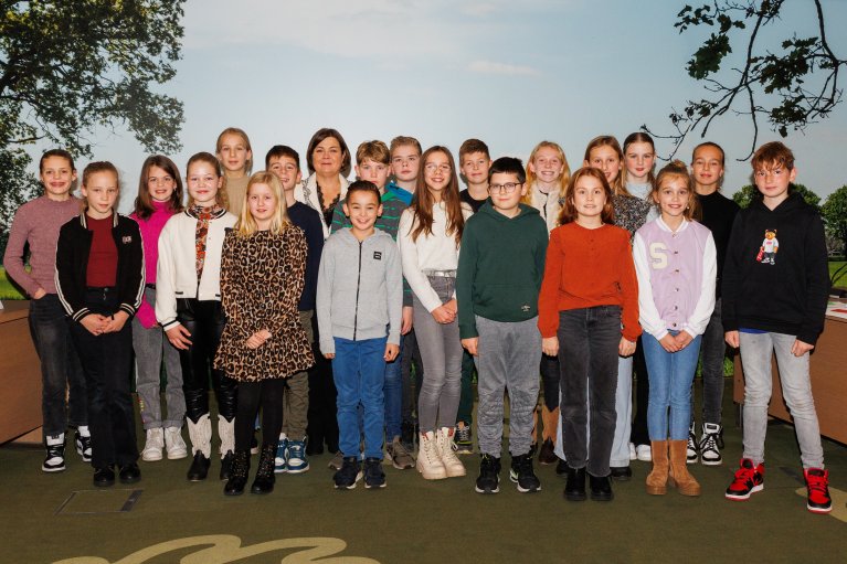 Basisschoolkinderen met burgemeester Arinda Callewaert op een groepsfoto