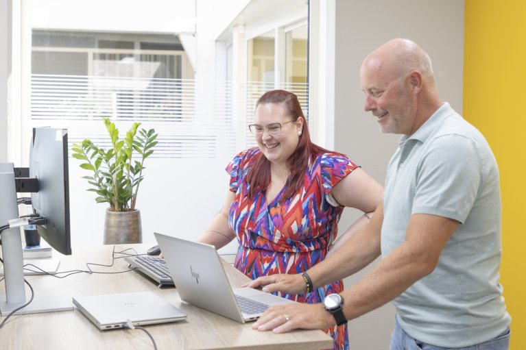 Collega's staan aan de laptop te werken