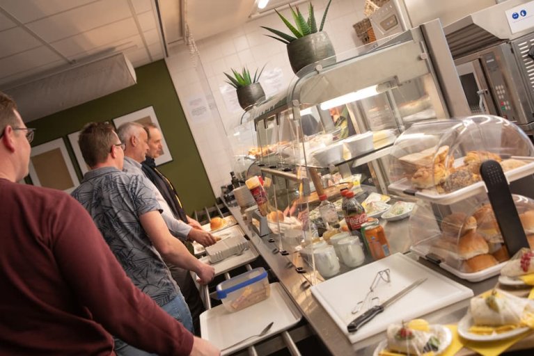 Medewerkers sluiten aan bij het zelfbedieningsbuffet in het bedrijfsrestaurant