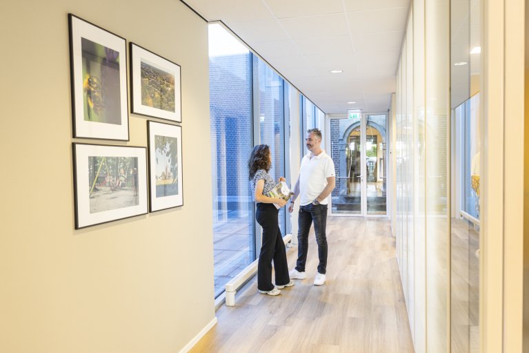 Twee pratende collega's op de gang