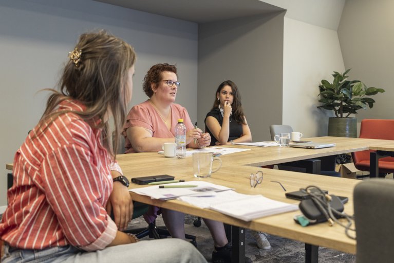 Collega's zitten aan tafel te vergaderen