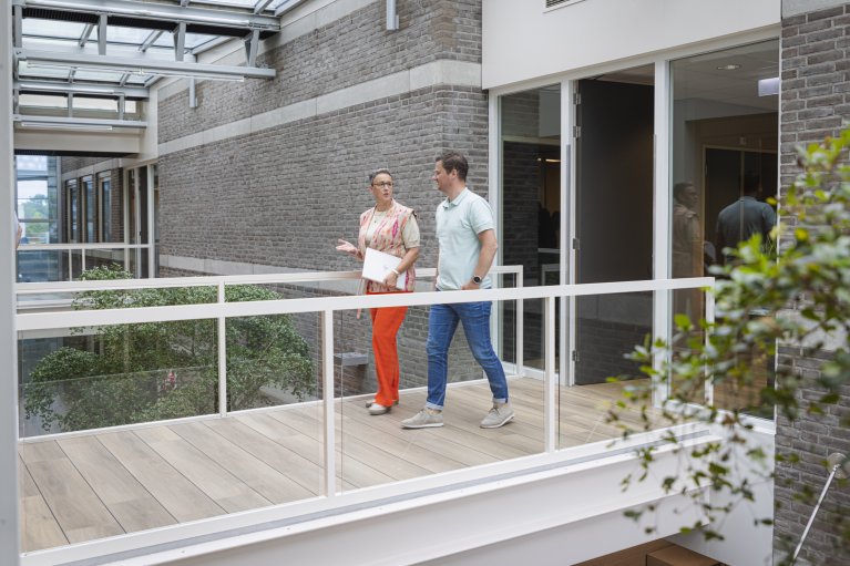 Twee lopende collega's in overleg met elkaar