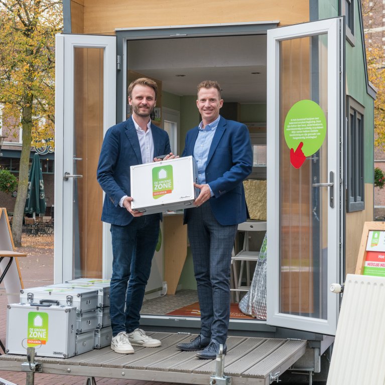 Wethouder Stef Luijten met in zijn handen een koffertje met de informatie over het isoleren van de woningen.