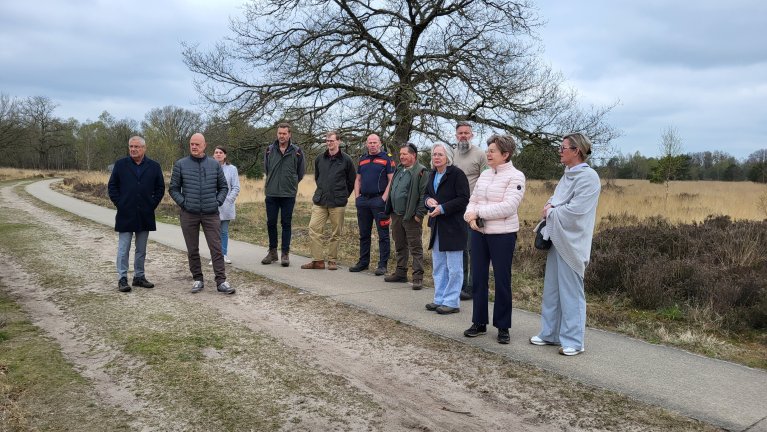 Burgemeester Wilma Delissen en collega's van andere gemeenten en de veiligheidsregio staan in een natuurgebied 