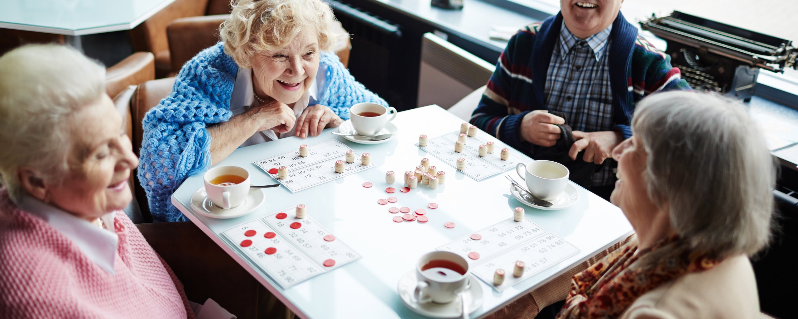 3 vrouwen en een man drinken koffie en spelen bingo