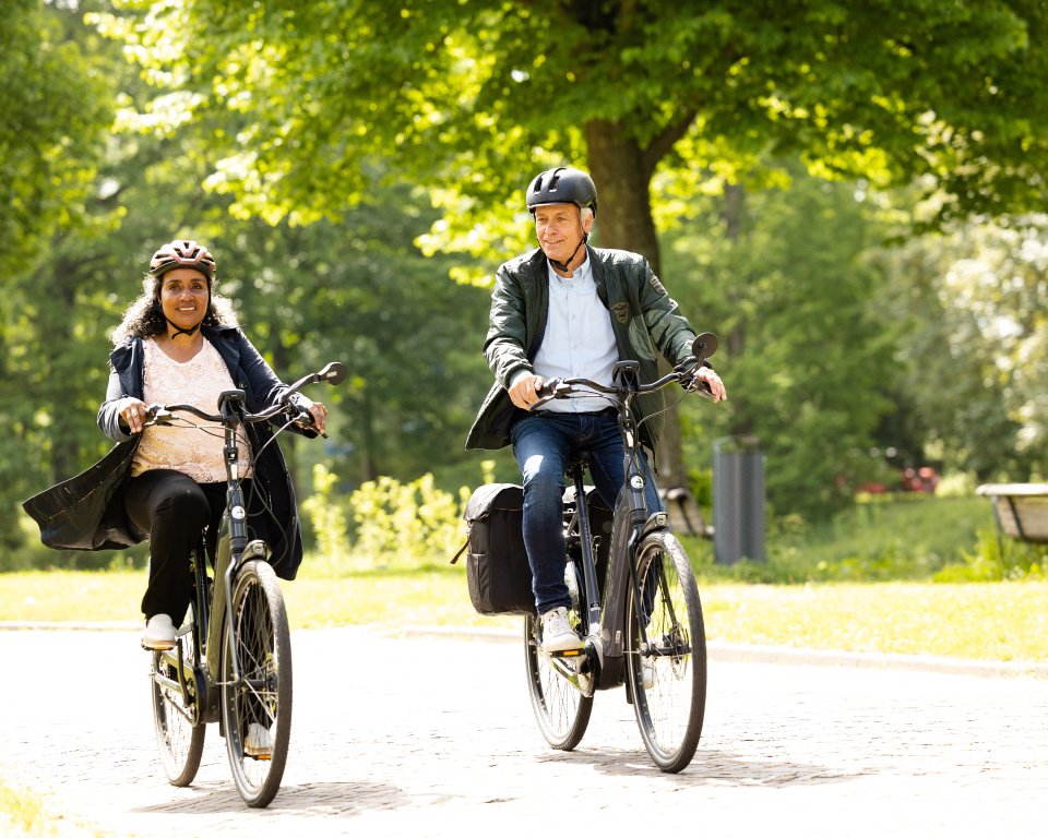 Twee mensen met helm op de fiets