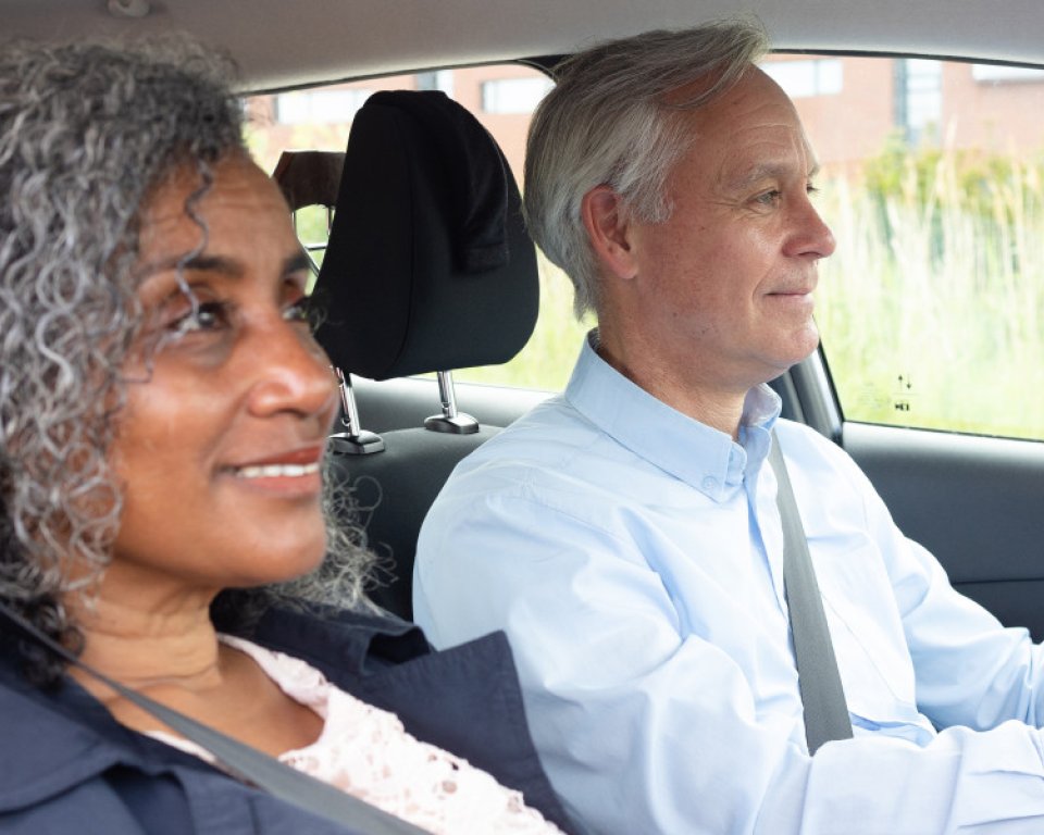 Man en vrouw in de auto, waarbij de man aan het stuur zit