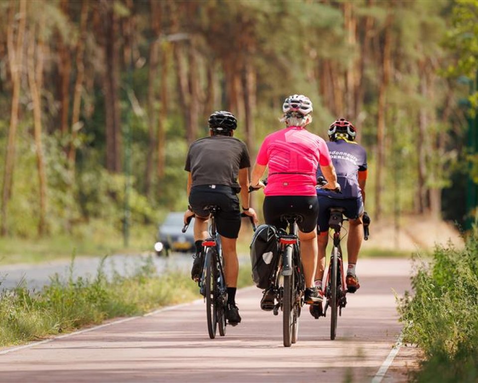 Drie fietsende mensen met helm op