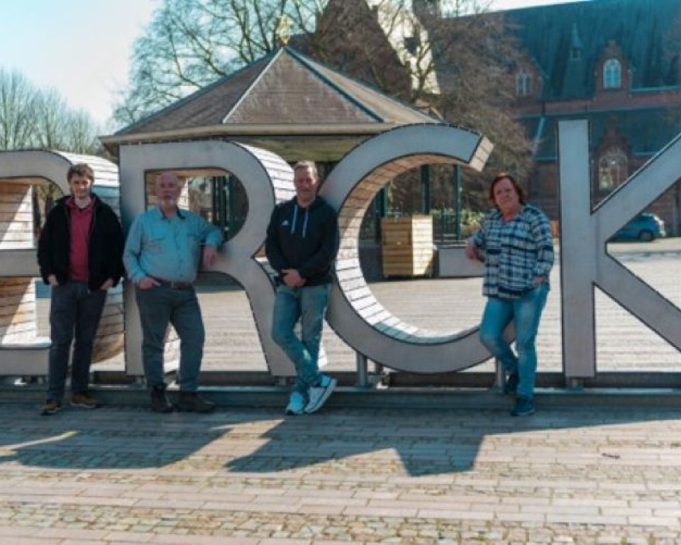 Leden nieuwe dorpsraad 't Hof staan bij de Bergeijk letters voor de kiosk
