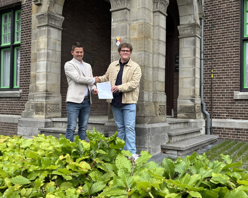 Mike Heesters en Tim Sonnenberg samen voor het gemeentehuis met het coalitieakkoord in de handen