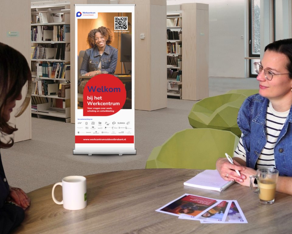 Twee dames zitten met elkaar in gesprek aan tafel