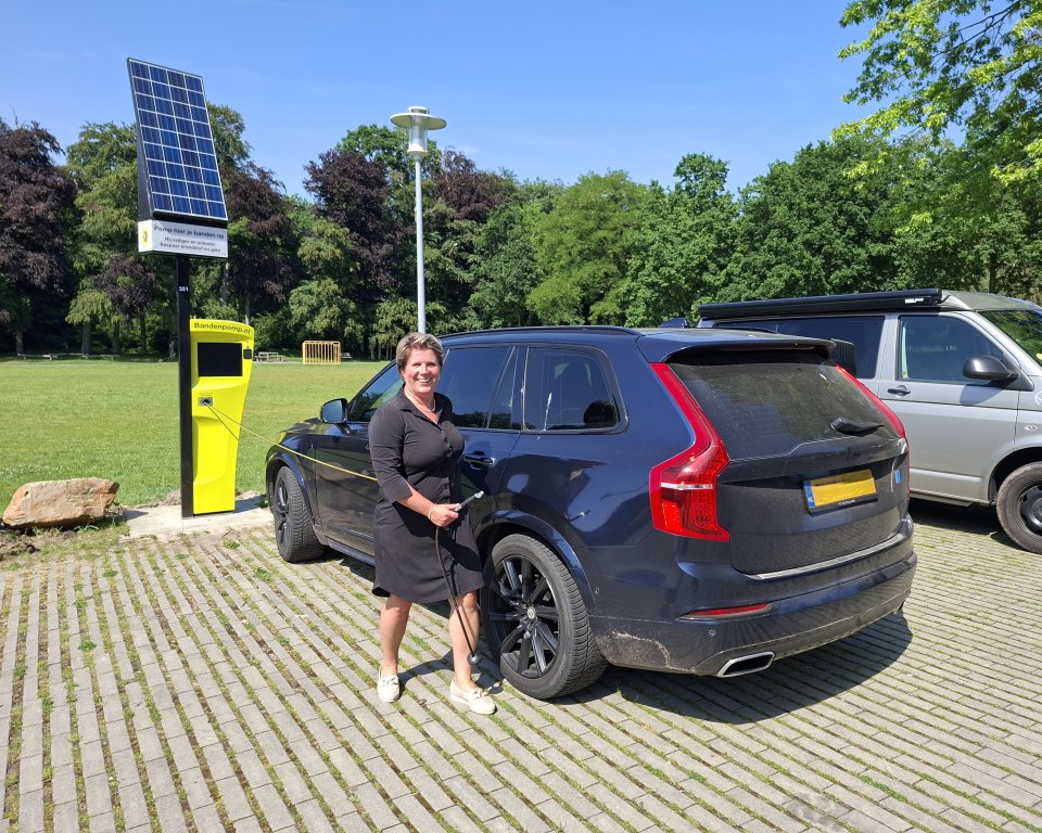 Lindy Wijnen staat met de slimme bandenpomp bij haar auto