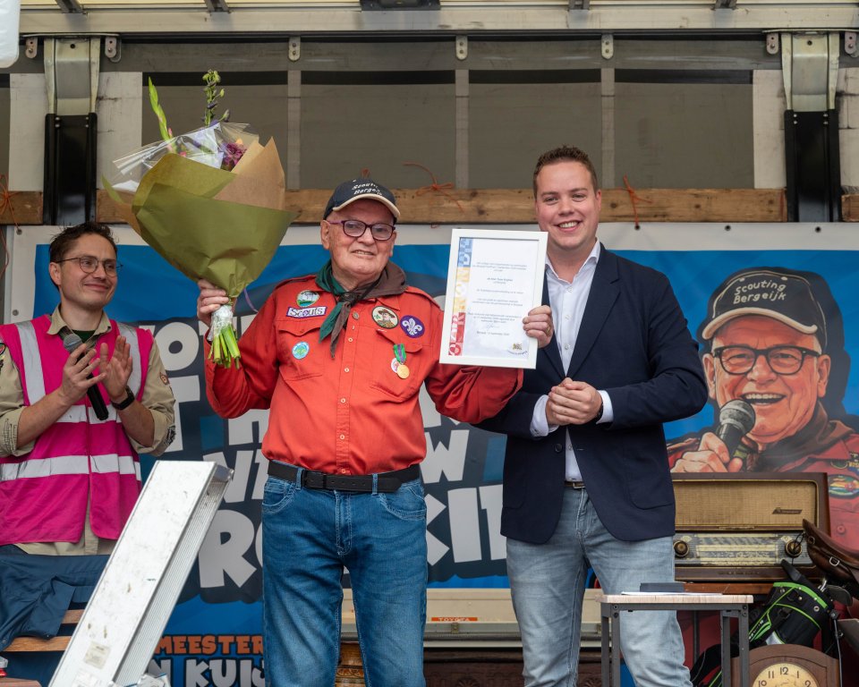 Toon Kuijken met wethouder Bjorn Aarts inclusief bos bloemen en vrijwilligersonderscheiding