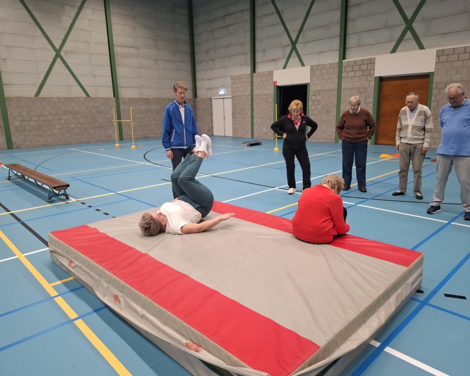Wethouder Lindy Wijnen ligt op de mat voor een oefening tijdens valpreventie