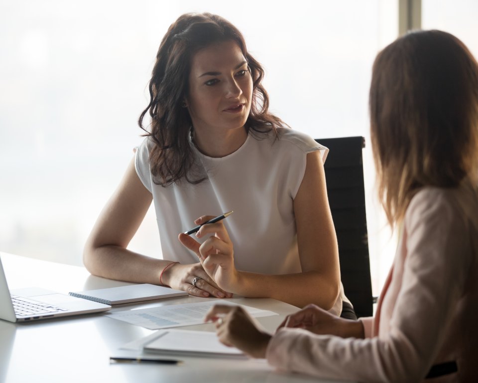 Twee mensen met elkaar in gesprek aan tafel