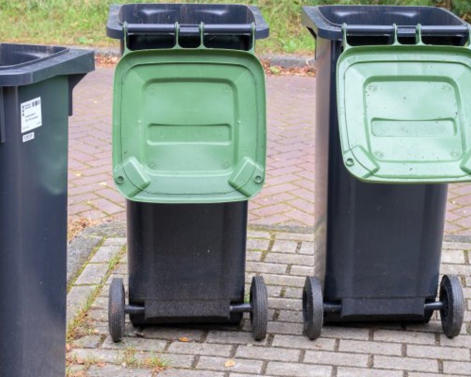 Drie zwarte kliko's met groene deksels die opengeklapt staan