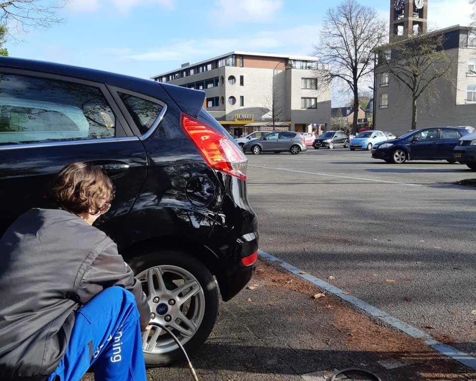Man zit bij een autoband om de spanning te checken
