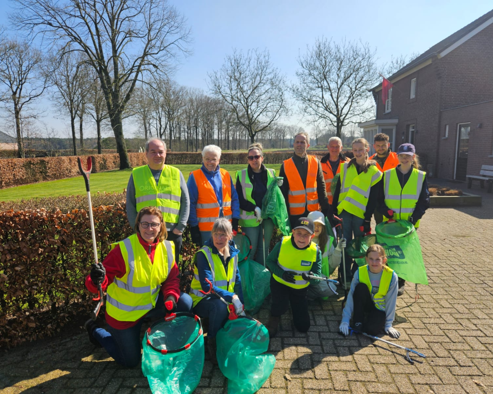 Vrijwilligers zwerfafval in hesjes als groep bij elkaar