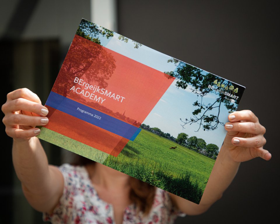 2 handen houden de folder van de BErgeijkSMART academy vast