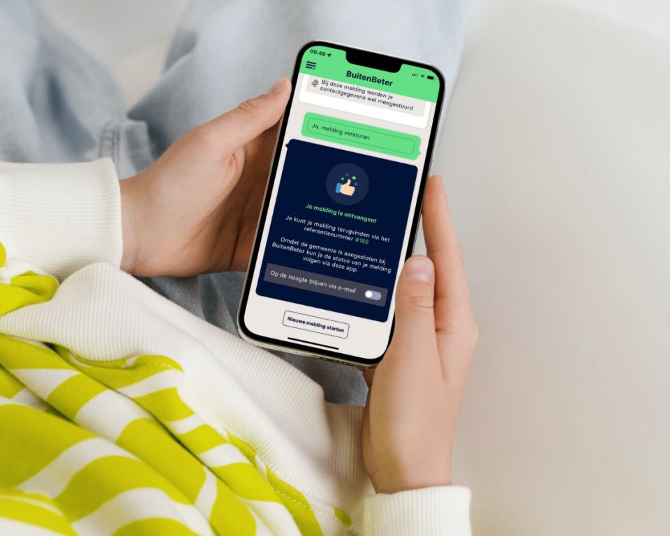 Iemand zit met een telefoon met daarop de buitenbeter app in de handen