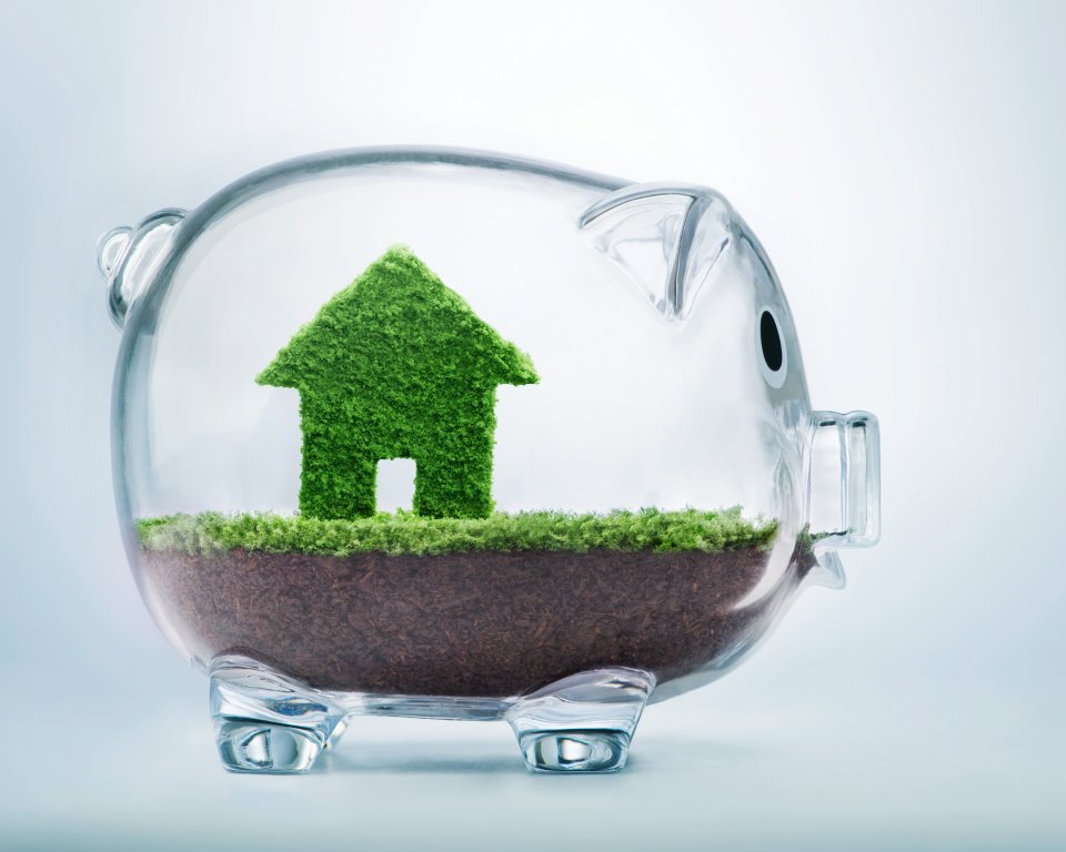 Doorzichtig spaarvarken met een huisje van gras erin afgebeeld