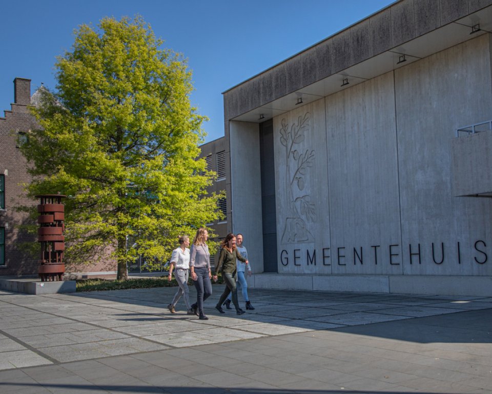 4 collega's  lopen voor het gemeentehuis