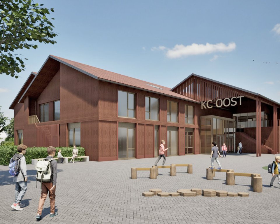 Impressie kindcentrum-oost met spelende kinderen op het plein voor de school met boom erbij