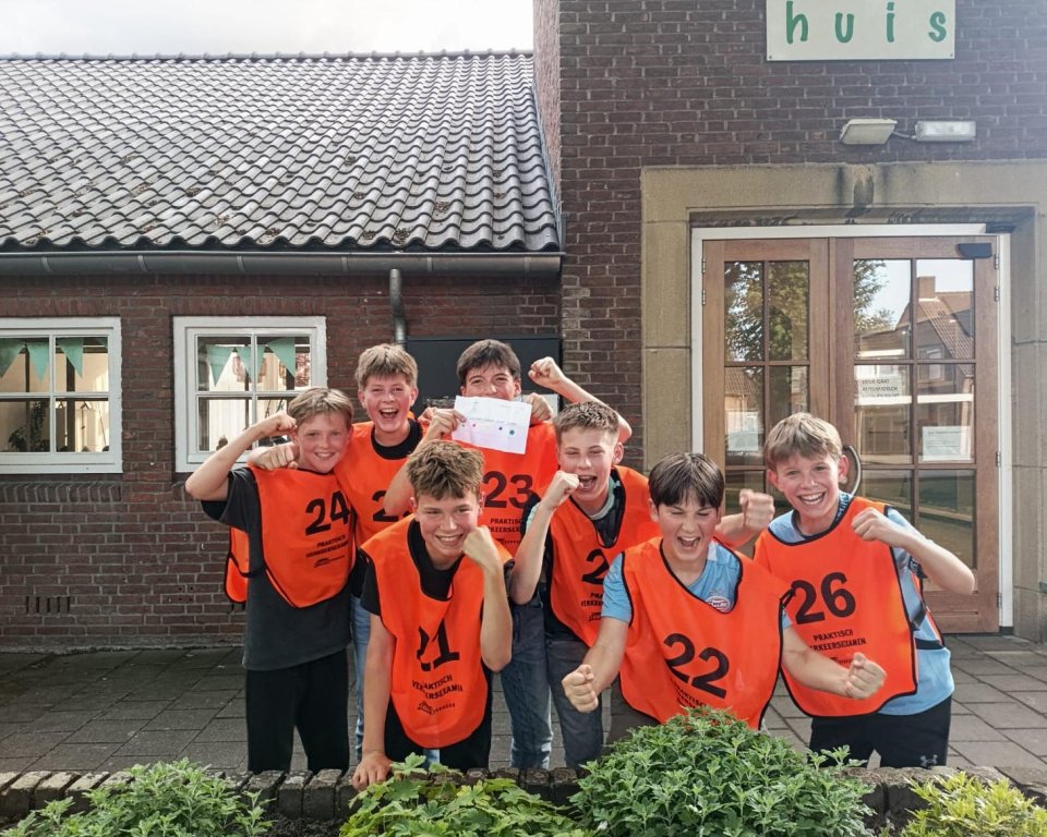 Aantal jongeren met oranje hesjes aan als een groepsfot