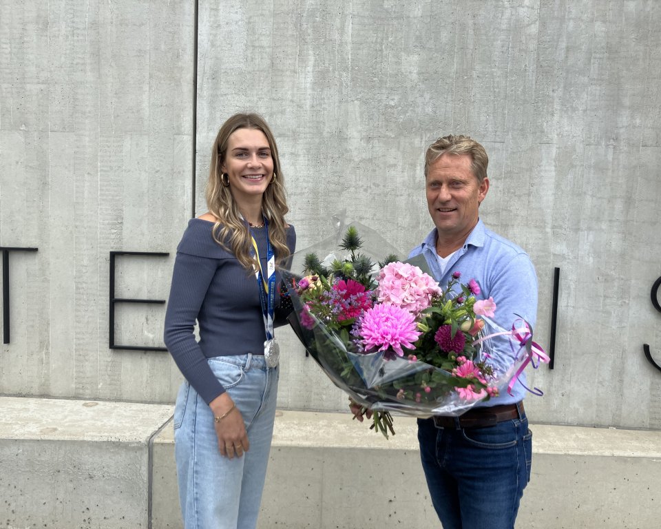 Jessie Heuveling en Wethouder sport, Mathijs Kuijken met bloemen voor het gemeentehuis