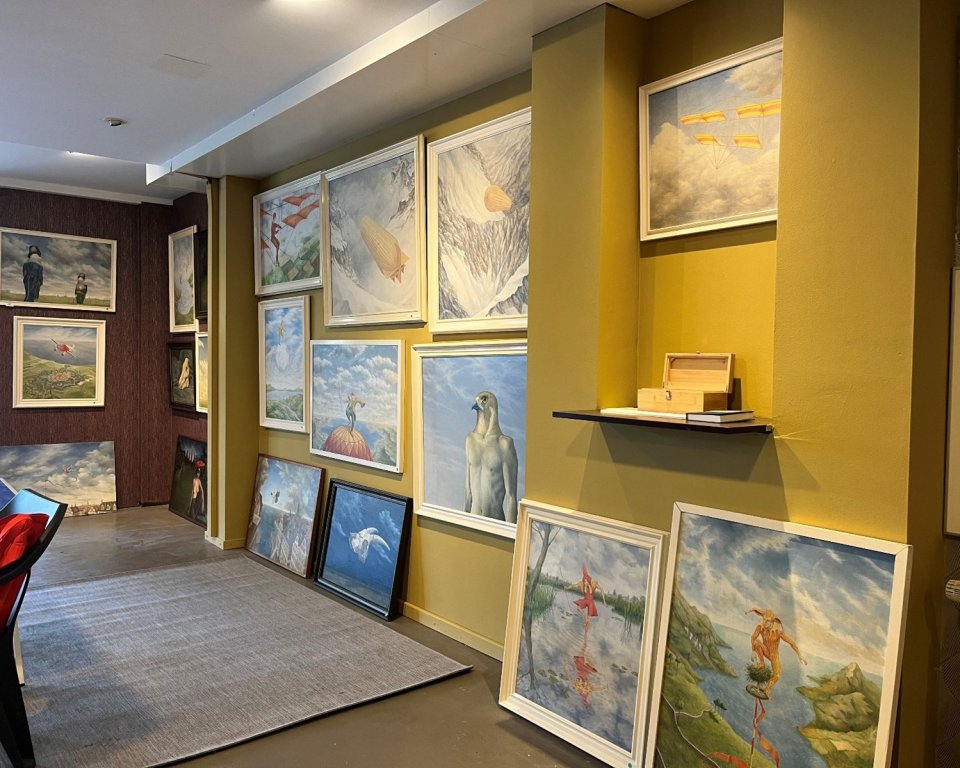 Schilderijen hangen aan de muur en staan op de grond