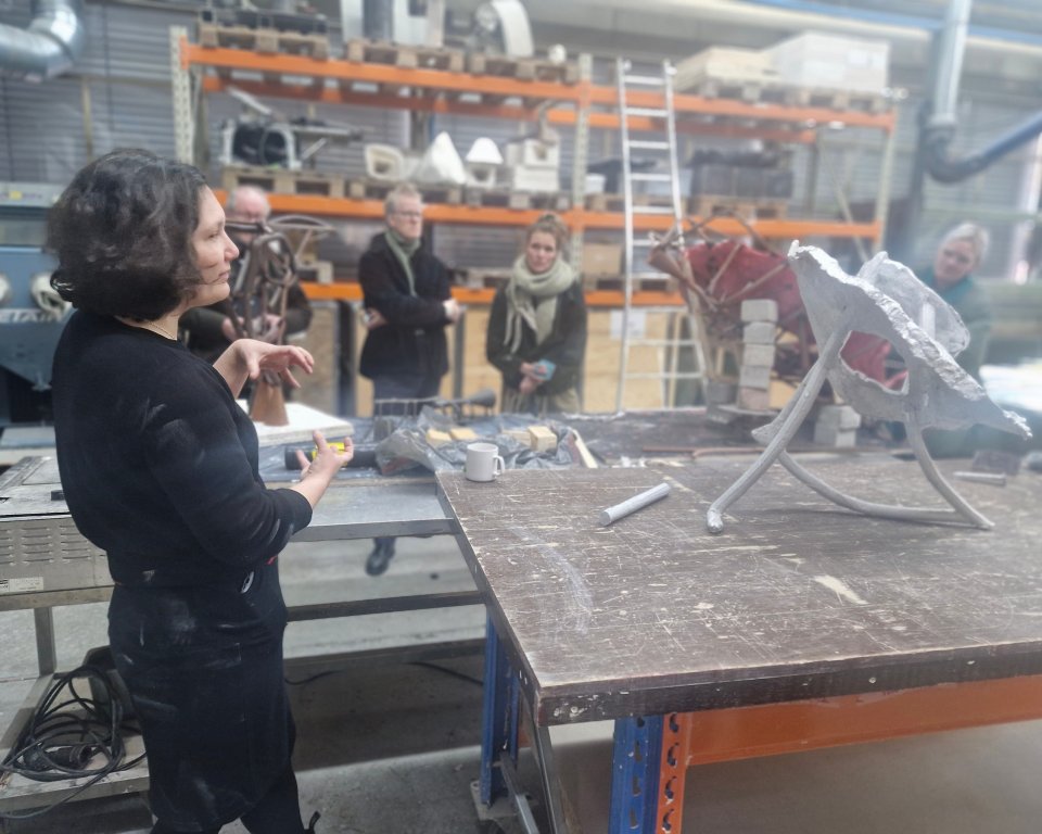 Kunstenares Dieke Venema staat in het atelier met bezoekers erbij