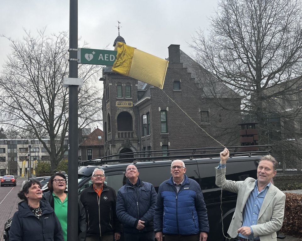 Wethouder Mathijs Kuijken onthult het aed bordje bij het gemeentehuis voor de deur.
