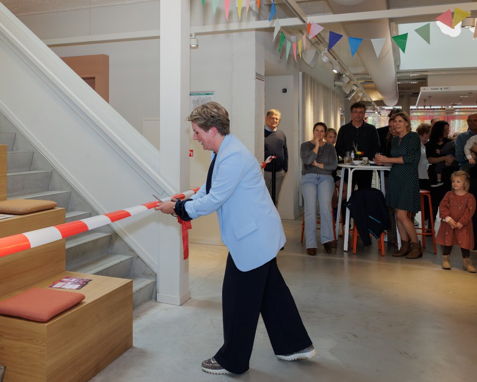 Wethouder Lindy Wijnen knipt het lint door bij de bibliotheek