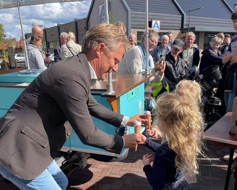 Wethouder Mathijs Kuijken deelt twee ijsjes uit aan twee meisjes